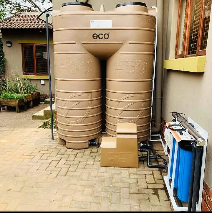Two water storage tanks installed on a paved courtyard